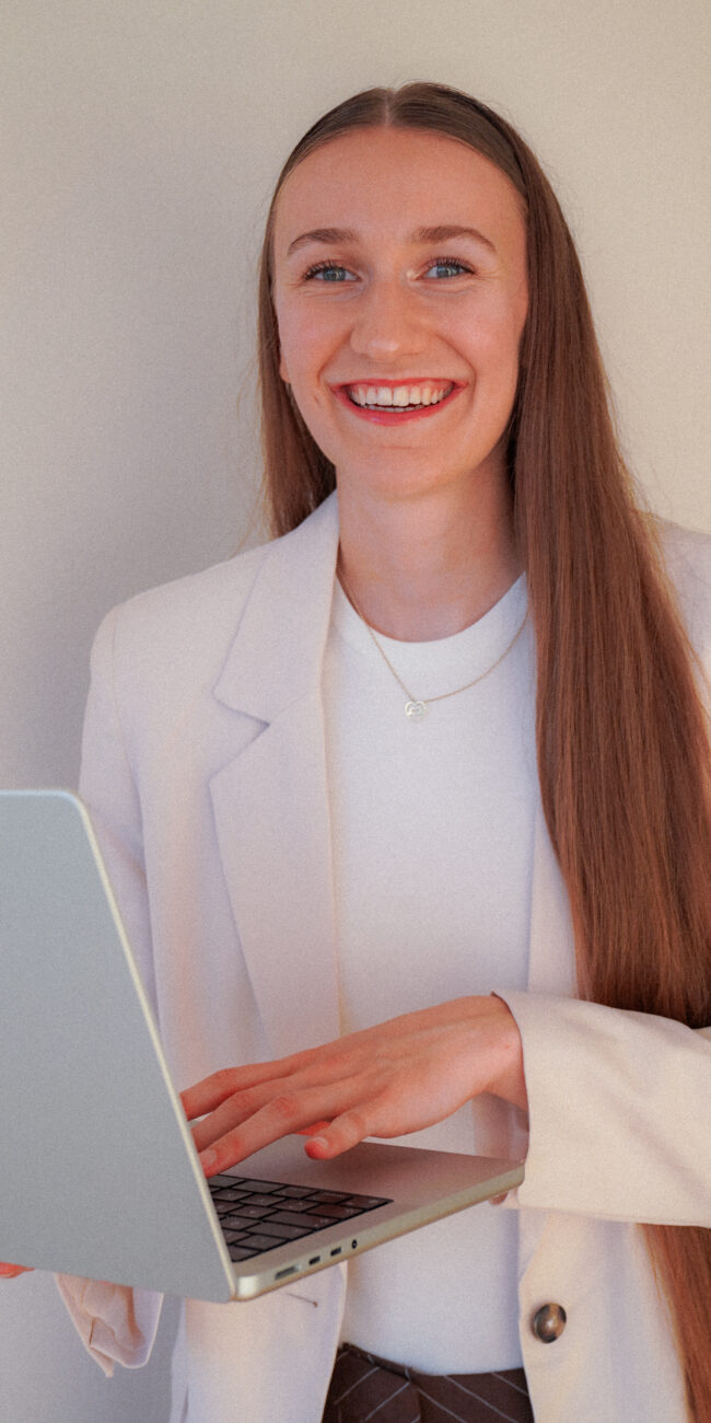 Finja Hintze, Hochzeitsplanerin, lächelnd mit Laptop
