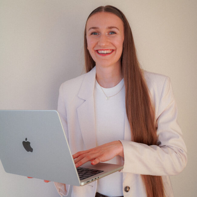 Finja Hintze, Hochzeitsplanerin, lächelnd mit Laptop